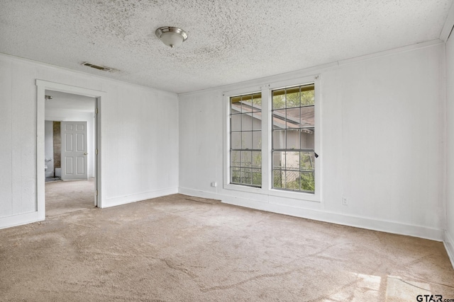 empty room with carpet, baseboards, a textured ceiling, and visible vents
