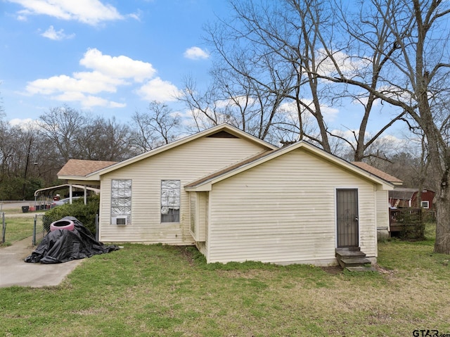 rear view of property featuring entry steps and a yard