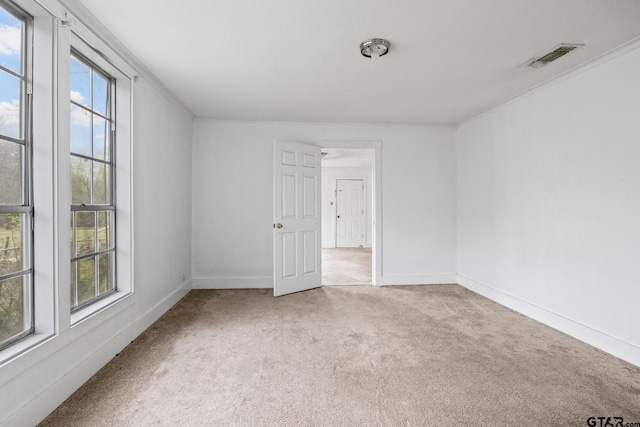 spare room with baseboards, carpet floors, visible vents, and plenty of natural light
