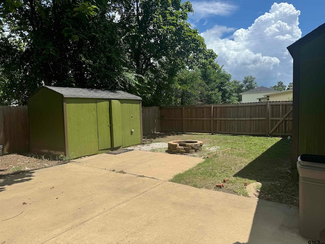 view of yard with a shed, a fire pit, and a patio area