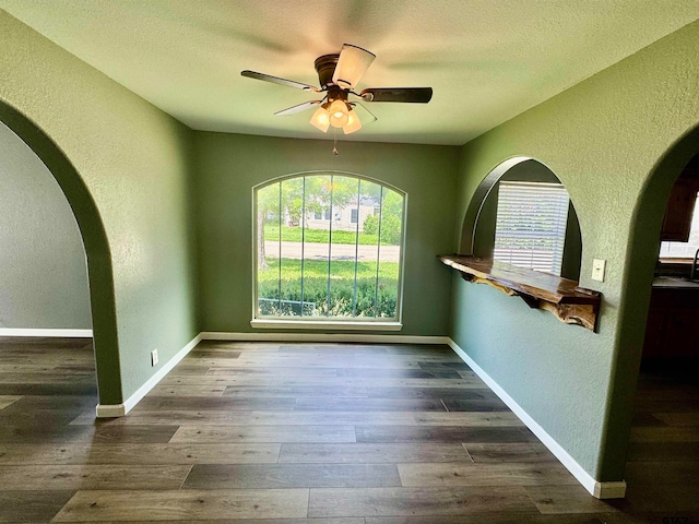 unfurnished room featuring ceiling fan, a textured ceiling, and dark hardwood / wood-style floors