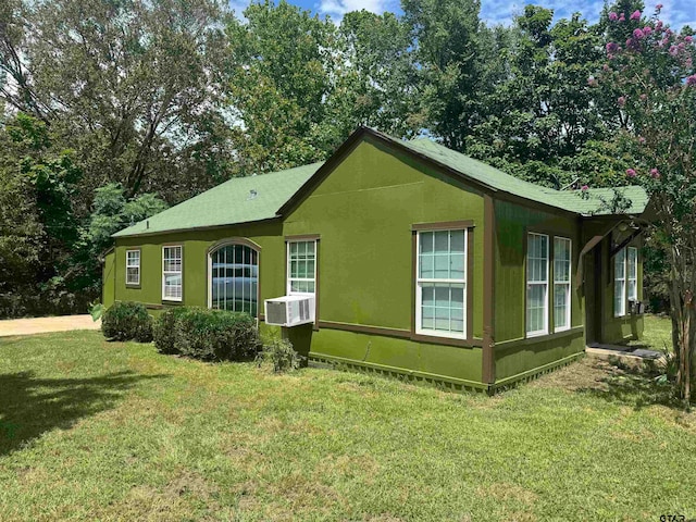 view of side of property featuring cooling unit and a yard