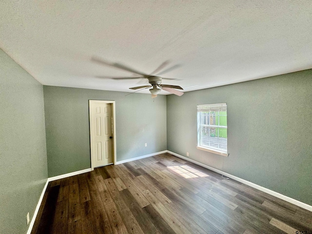 spare room featuring dark hardwood / wood-style flooring, a textured ceiling, and ceiling fan