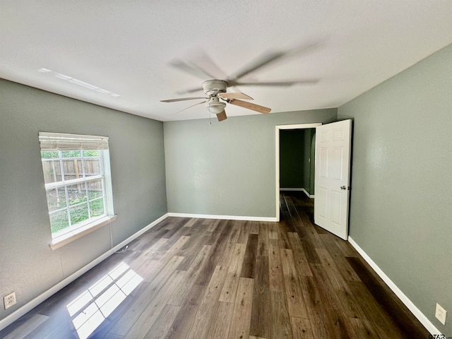 unfurnished room with ceiling fan and dark hardwood / wood-style floors