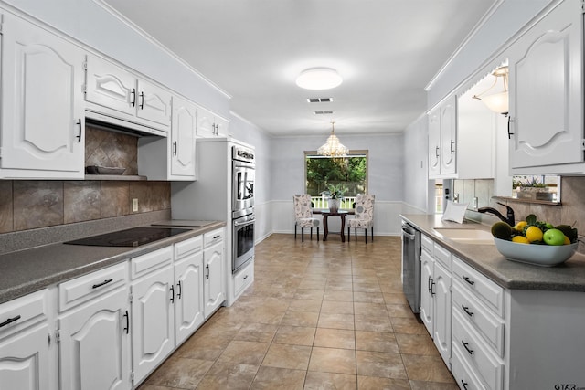 kitchen featuring decorative backsplash, appliances with stainless steel finishes, sink, and white cabinets