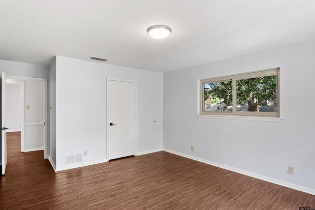 unfurnished bedroom with dark wood-type flooring and a closet