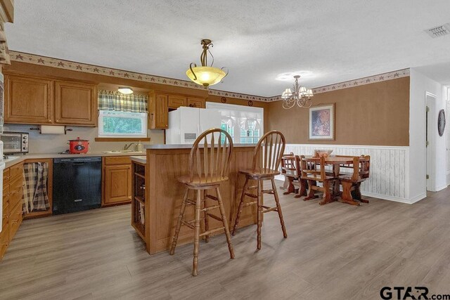 226 Circle Ridge Dr, Gilmer, TX 75645 - kitchen with black dishwasher, a sink, light wood-style floors, a chandelier, and wainscoting