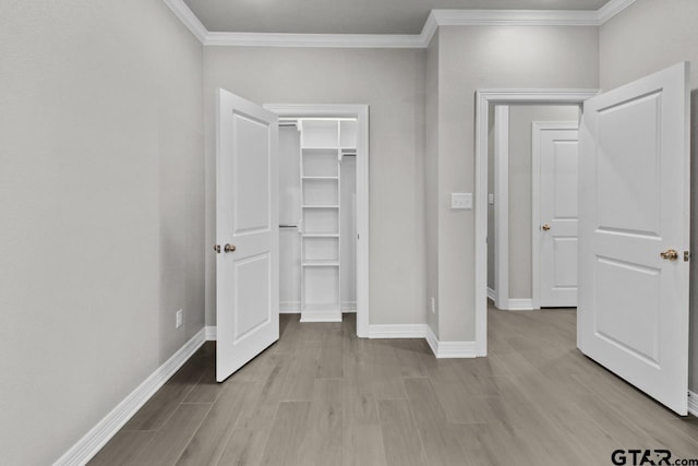 unfurnished bedroom featuring a closet, ornamental molding, and light hardwood / wood-style flooring