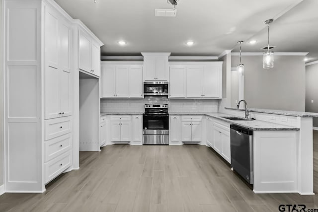 kitchen featuring white cabinets, hanging light fixtures, sink, and appliances with stainless steel finishes