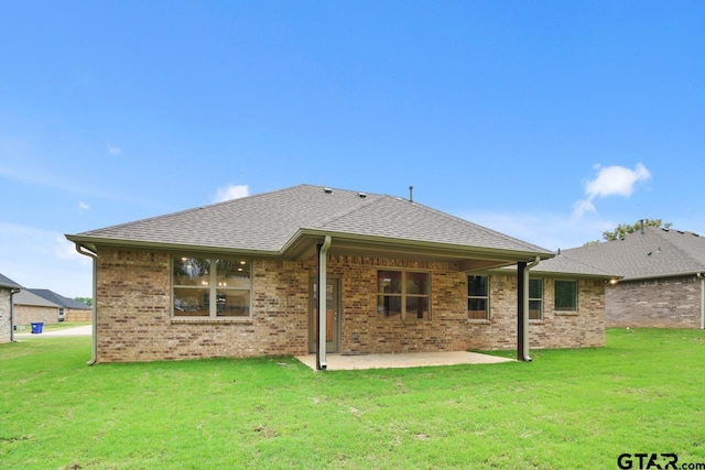 rear view of house with a lawn and a patio