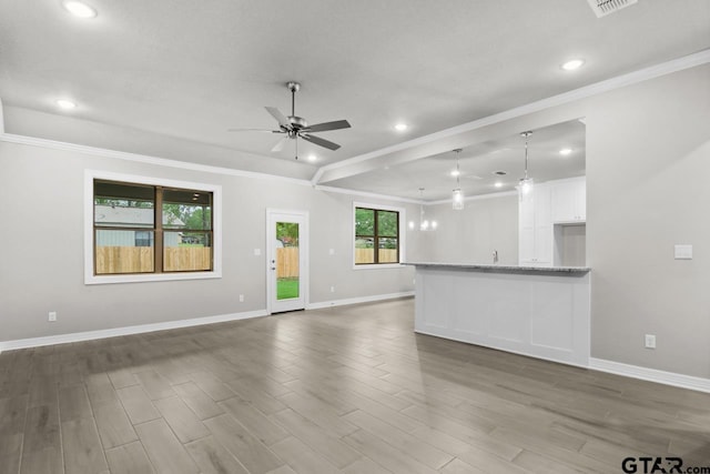 unfurnished living room featuring crown molding, ceiling fan, and dark hardwood / wood-style floors