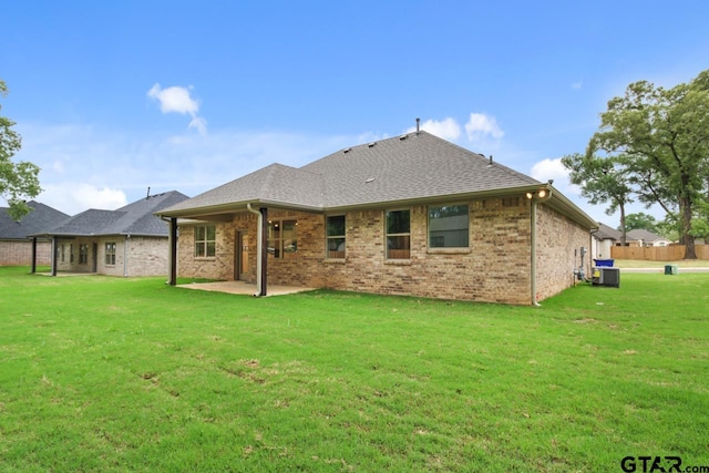 rear view of property with a yard, cooling unit, and a patio area