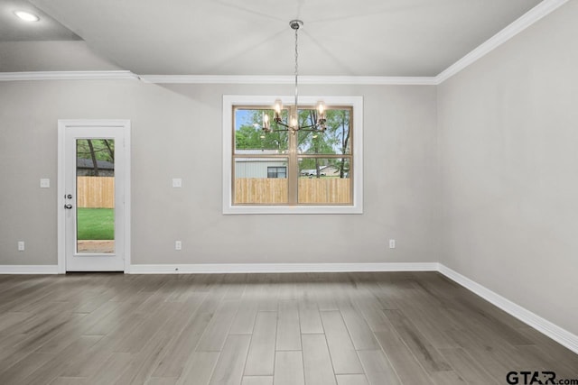 unfurnished dining area with a chandelier, hardwood / wood-style floors, and ornamental molding