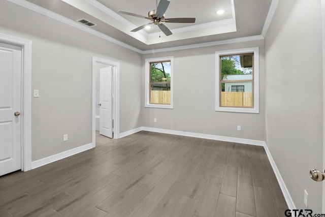 unfurnished bedroom featuring a raised ceiling, ceiling fan, crown molding, and wood-type flooring