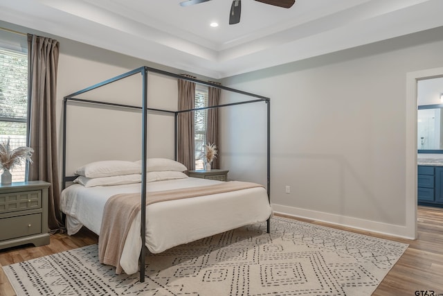 bedroom with recessed lighting, a raised ceiling, a ceiling fan, light wood-type flooring, and baseboards