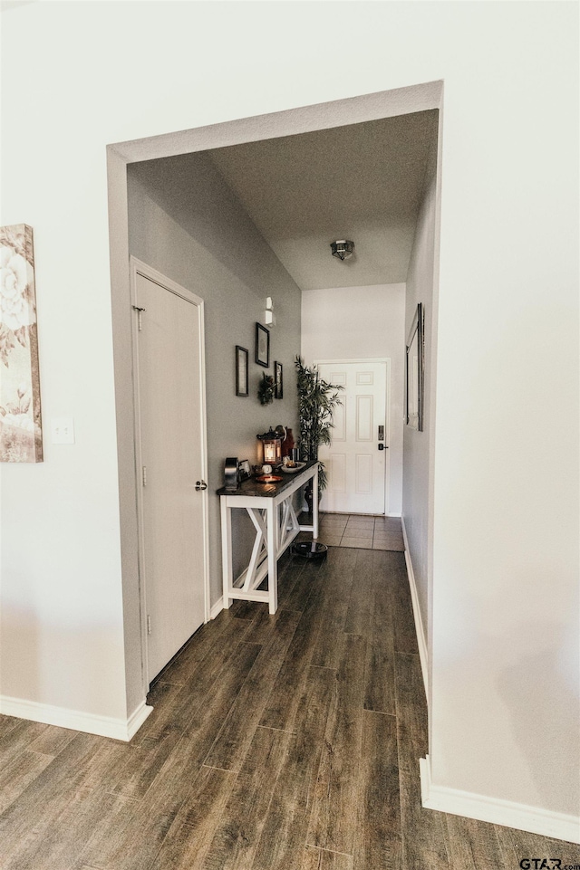 hallway with dark wood-style floors and baseboards