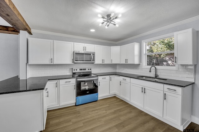 kitchen featuring stainless steel appliances, sink, dark stone counters, and white cabinets