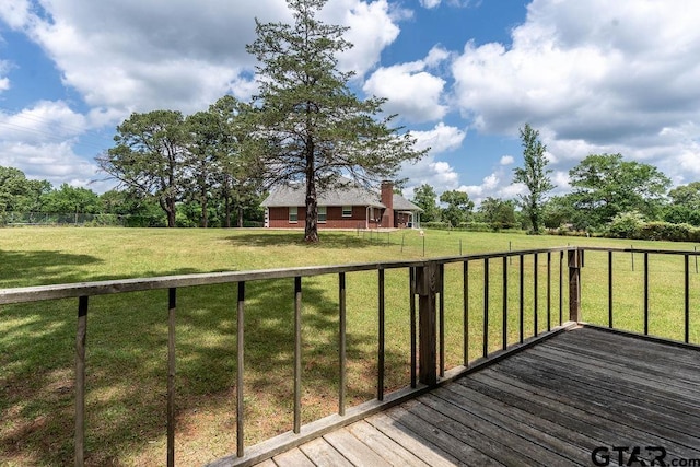wooden terrace featuring a yard