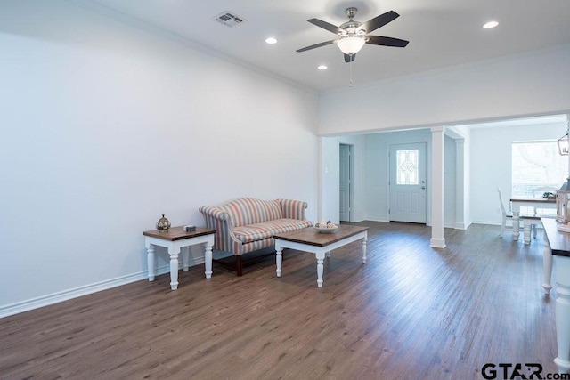 living area featuring visible vents, crown molding, ceiling fan, and wood finished floors
