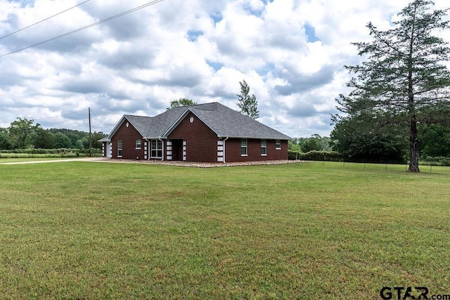 view of home's exterior with brick siding and a yard