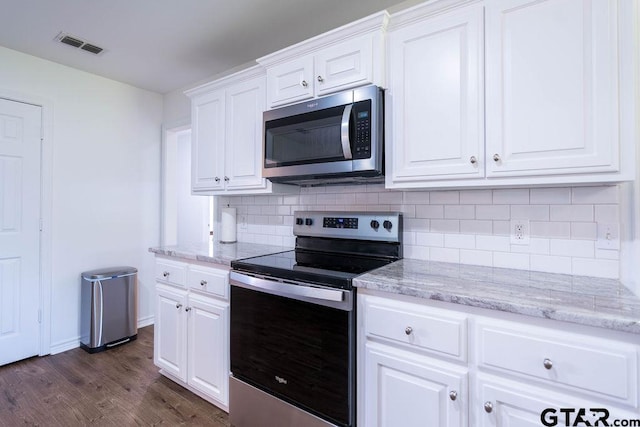 kitchen featuring appliances with stainless steel finishes, tasteful backsplash, dark wood finished floors, and visible vents
