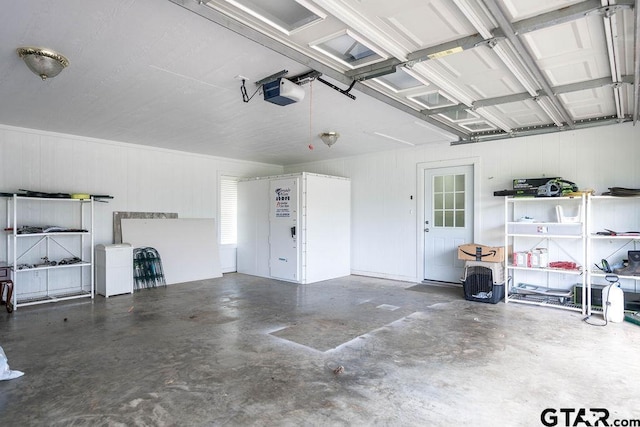 garage featuring wood walls and a garage door opener
