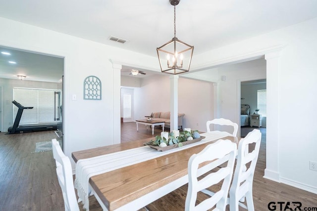dining area with baseboards, a notable chandelier, visible vents, and wood finished floors