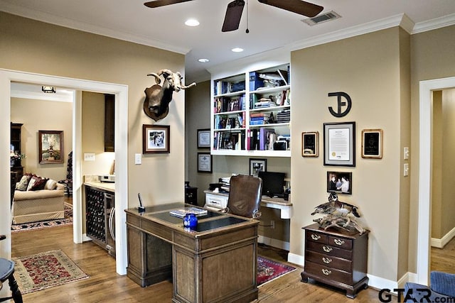 office featuring visible vents, ceiling fan, beverage cooler, ornamental molding, and wood finished floors