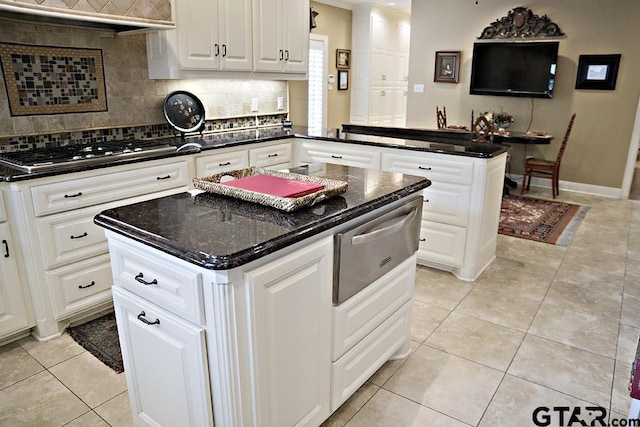 kitchen with decorative backsplash, a peninsula, light tile patterned flooring, and stainless steel gas cooktop