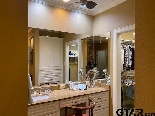 bathroom with a closet, a ceiling fan, ornamental molding, and vanity