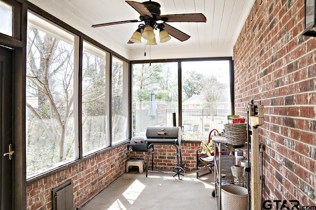 sunroom / solarium with a healthy amount of sunlight and ceiling fan