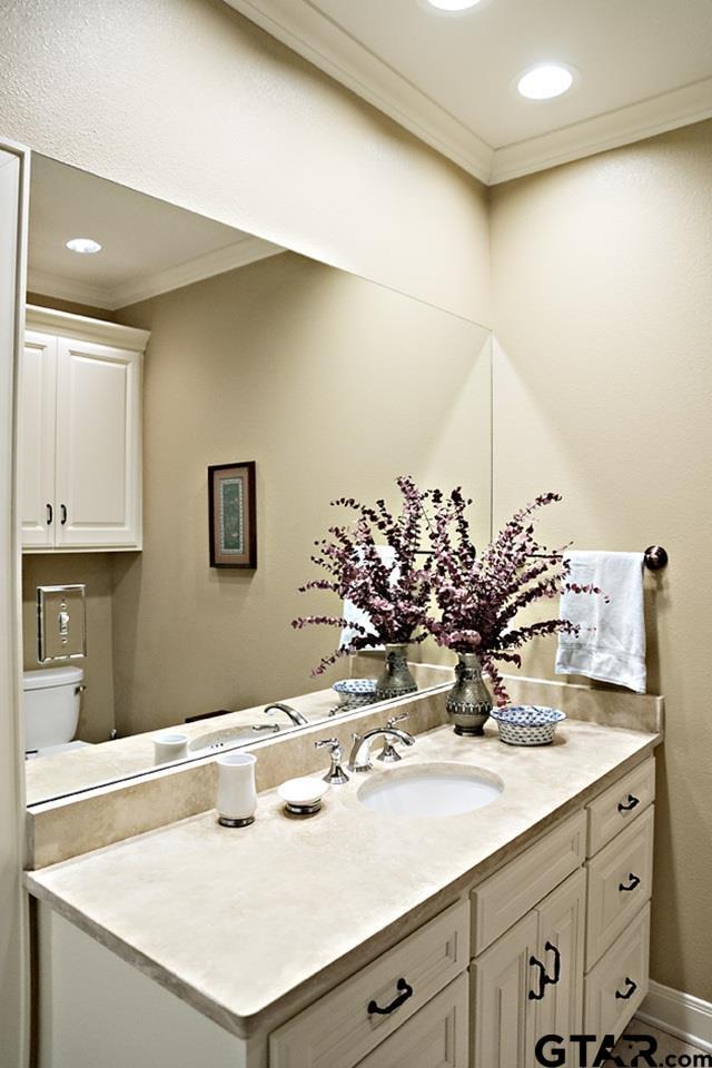 bathroom with recessed lighting, vanity, baseboards, and ornamental molding