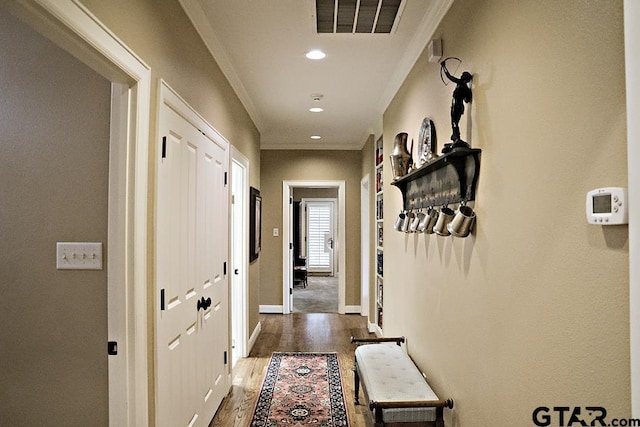 hall with visible vents, baseboards, dark wood finished floors, ornamental molding, and recessed lighting