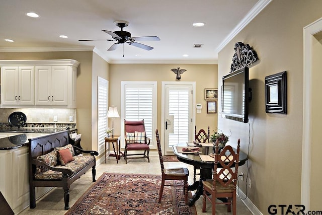 dining space featuring visible vents, baseboards, crown molding, and ceiling fan