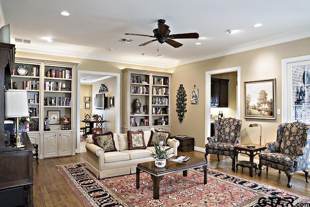 living room with ceiling fan, visible vents, dark wood finished floors, and crown molding