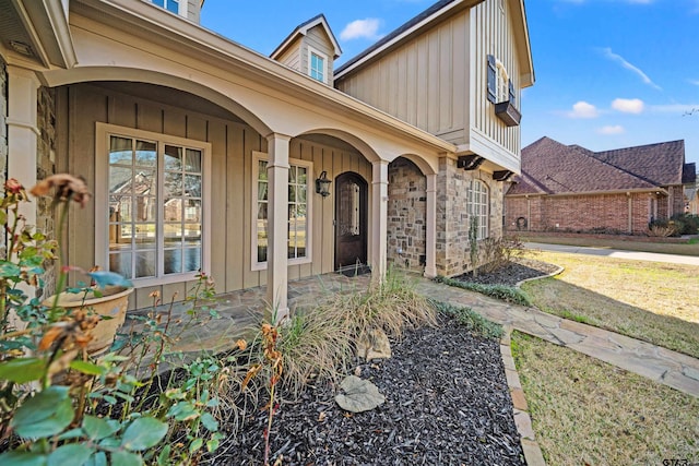 entrance to property with board and batten siding and stone siding