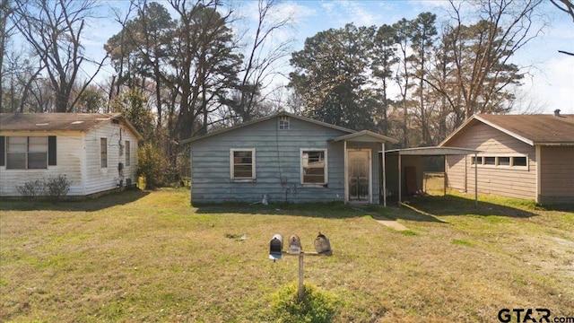 rear view of property featuring a lawn