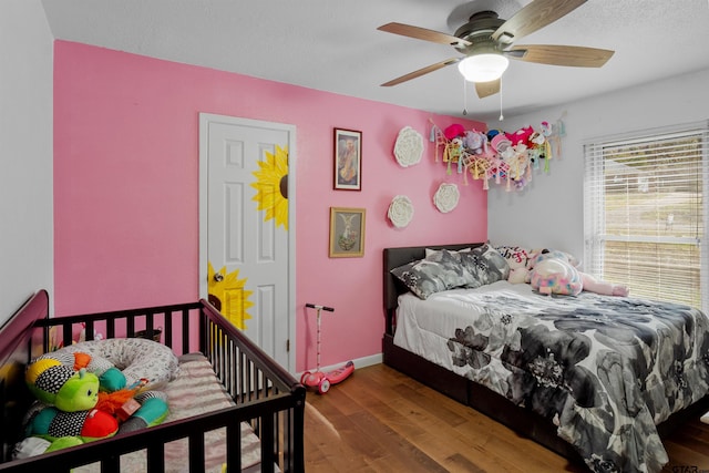 bedroom featuring hardwood / wood-style floors, ceiling fan, and a textured ceiling