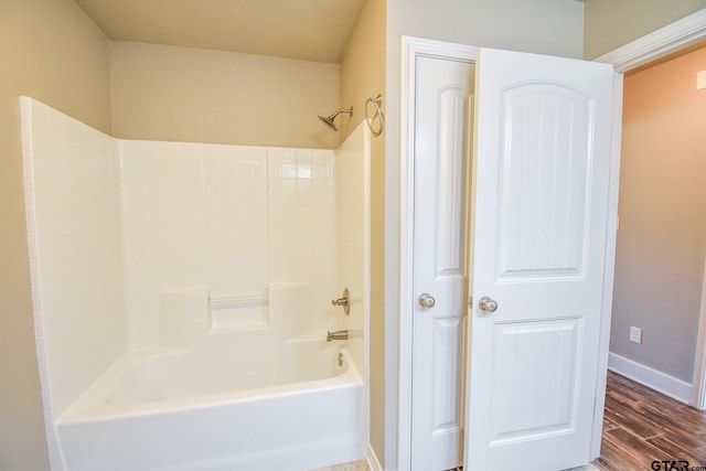 bathroom with hardwood / wood-style flooring and  shower combination