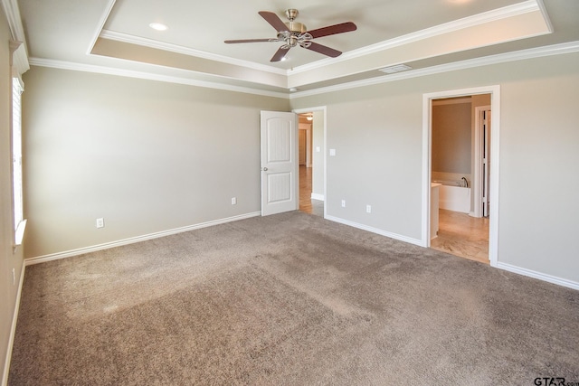 unfurnished bedroom with ceiling fan, a raised ceiling, and carpet