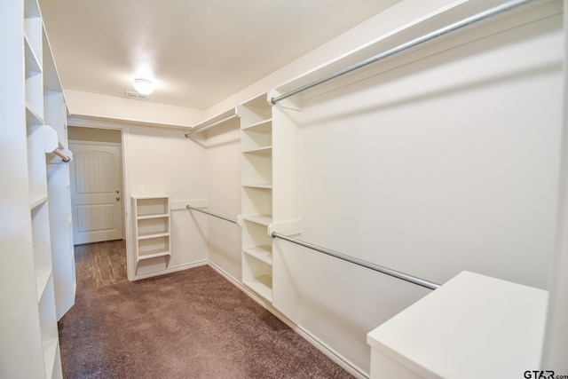 spacious closet with dark colored carpet