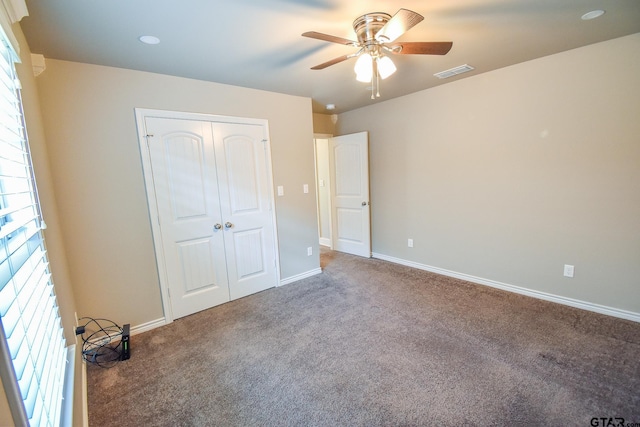 unfurnished bedroom with ceiling fan, carpet, and a closet