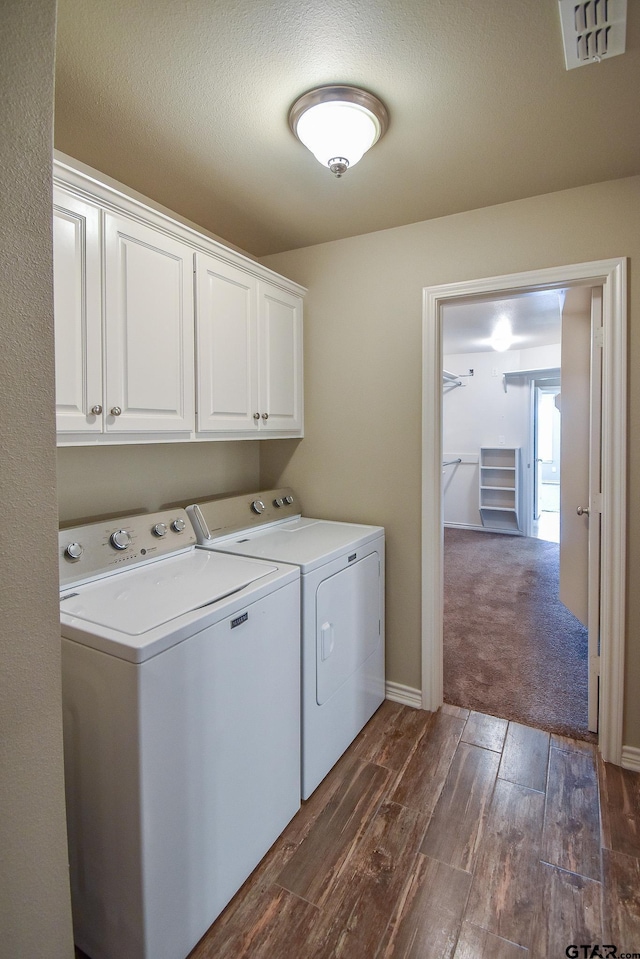 clothes washing area featuring cabinets and independent washer and dryer