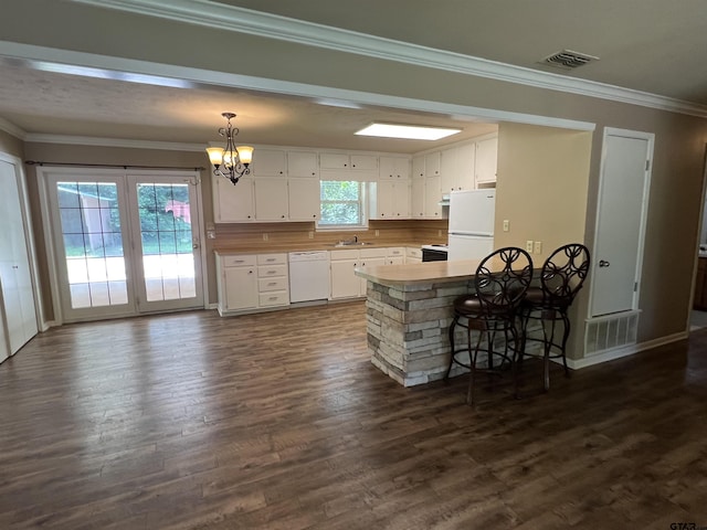 117 Harvey St, Rusk, TX 75785 - kitchen with white appliances, a chandelier, white cabinetry, ornamental molding, and dark wood-type flooring