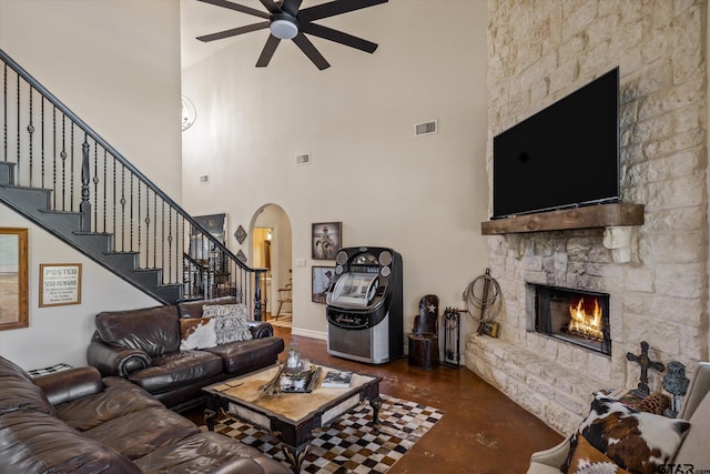 living room featuring a fireplace and a towering ceiling