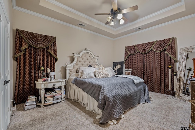 carpeted bedroom with ceiling fan, crown molding, and a tray ceiling