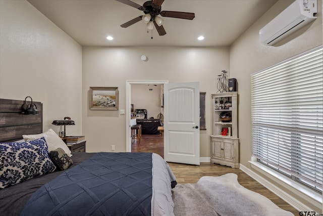 bedroom featuring light wood-type flooring, ceiling fan, and an AC wall unit