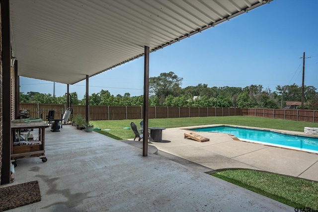 view of pool featuring a patio and a yard