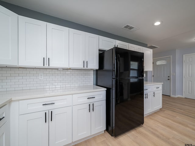 kitchen featuring visible vents, white cabinets, light countertops, freestanding refrigerator, and light wood-style floors