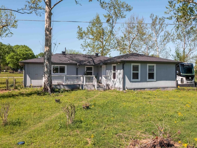back of house with fence, a deck, and a lawn